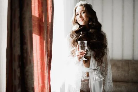 Gorgeous bride in robe posing and preparing for the wedding ceremony face in a Stock Photos
