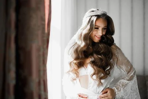 Gorgeous bride in robe posing and preparing for the wedding ceremony face in a Stock Photos