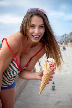 Gorgeous Brunette Model Eats Ice Cream And Skates At The Beach Stock Photos