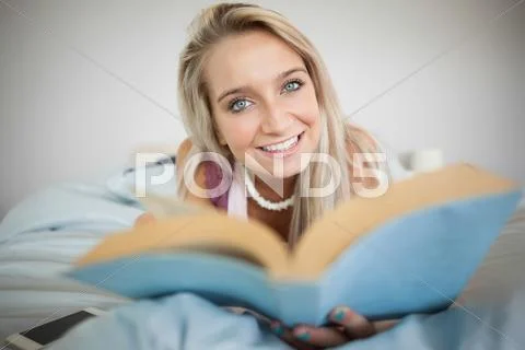 Gorgeous cheerful blonde holding a book Stock Photos