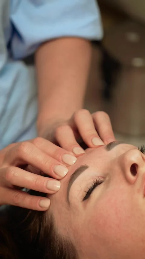 Gorgeous client undergoing rejuvenating face therapy executed by esthetician Stock Footage 314430134