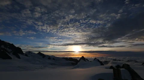 Gorgeous clouds and sunset over snowy mountain top Video stock 55539344
