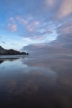 Gorgeous clouds reflections at the Te Henga Beach Stock Photos