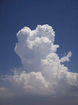 A gorgeous cumulus cloud in the rays of the sun on a blue sky. Stock Photos