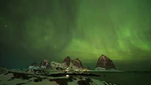Gorgeous display of the Aurora Borealis casting an ethereal glow over a snowy 動画素材 334659213