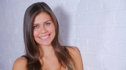 Gorgeous Female Model Turning To Camera Smiling Against brick Wall Vídeos de archivo 62820903