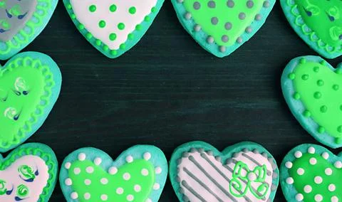 Gorgeous frames of lime green tone heart shaped cookies on black background Stock Photos