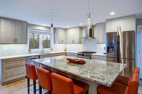 Gorgeous kitchen design features ivory kitchen cabinets flanking modern steel Stock Photos
