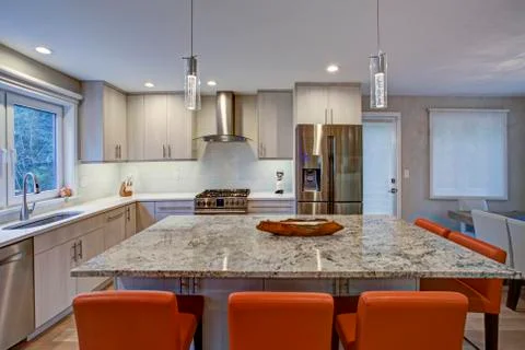 Gorgeous kitchen design features ivory kitchen cabinets flanking modern steel Stock Photos