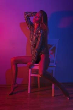 Gorgeous lady in glitter jacket posing on chair Foto stock