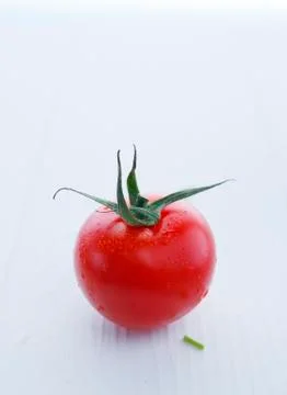 Gorgeous red tomato with stem on white Stock Photos