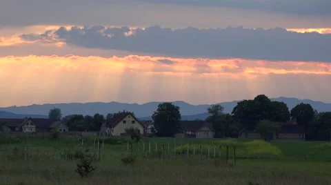 Gorgeous scenery, sun rays lighting behind clouds, evening over village 4K Video stock 46207359