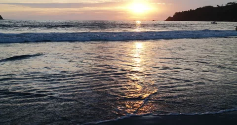 Gorgeous sun reflection on the beach at sunset. Close up water splashing. Stock Footage 154864725