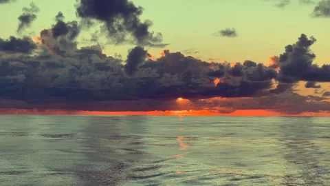 Gorgeous sunset over the ocean with dark clouds creating a dramatic sky and.. Stock Footage 338281827