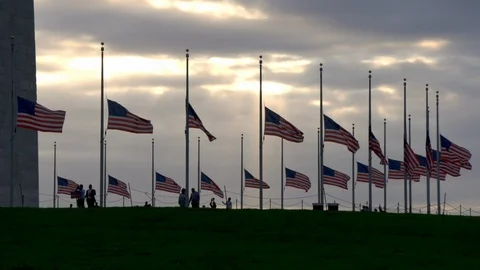 Gorgeous sunset shot of flags at half-mast at  Washington monument. Stock Footage 126941687