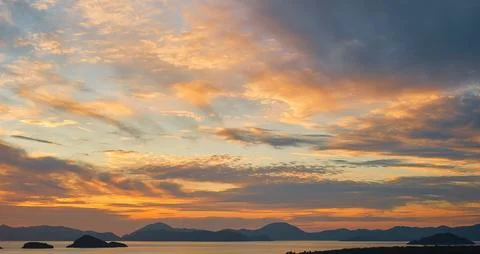 Gorgeous sunset sky with clouds over the sea. Silhouettes of a range of isl.. Photos