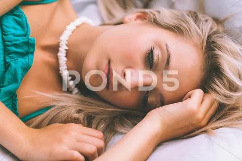 Gorgeous thoughtful blonde lying on bed posing Stock Photos