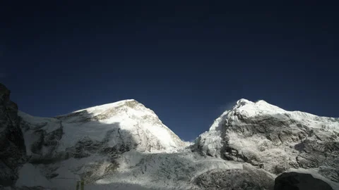 Gorgeous timelapse. Chaotic clouds swirl in blue sky above snow mountains summit Stock Footage 167364448