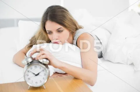 Gorgeous tired woman lying on her bed Stock Photos