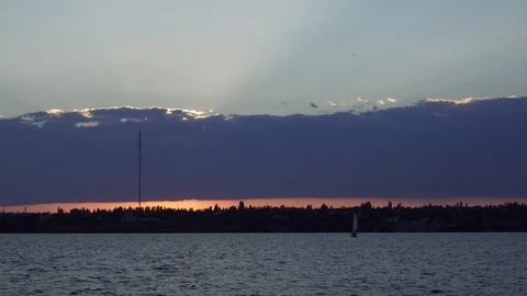 Gorgeous warm orange evening sunset in cloudy sky over calm river water waves in Stock Footage 94823894