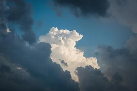 Gorgeous white cloud through many dark blue clouds Stock Photos