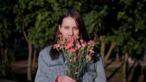 Gorgeous white model smiling and sniffing a bouquet of pink and red flowers Vidéo 197336127