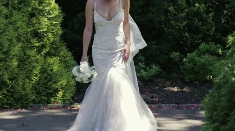 Gorgeous young bride in nice wedding dress and bridal vail comes up to camera Video stock 67475373