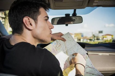 Gorgeous Young Man Inside Car Asking for Directions Holding a Map Close up... Stock Photos