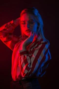 Gorgeous young model in glasses posing with red and blue studio light Stock Photos