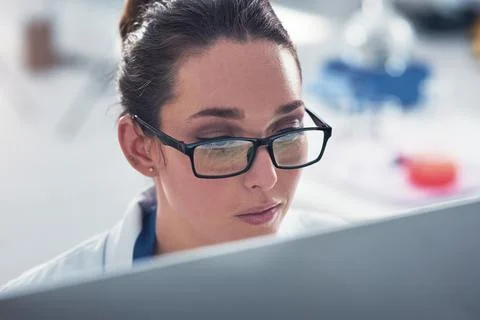 Got to check the data. a focused young female scientist working on a computer Stock Photos