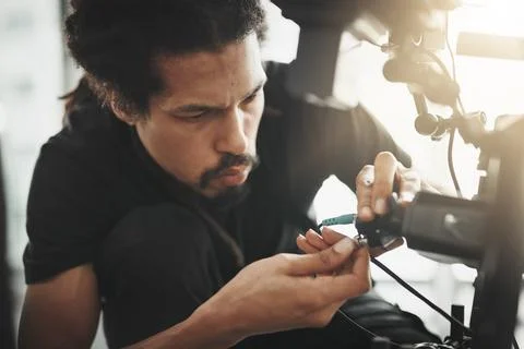 Got to get these wires sorted. Behind the scenes shot of a camera operator Stock Photos