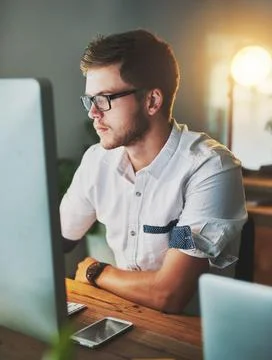 Got to keep working. a young designer working on a computer while wearing Stock Photos