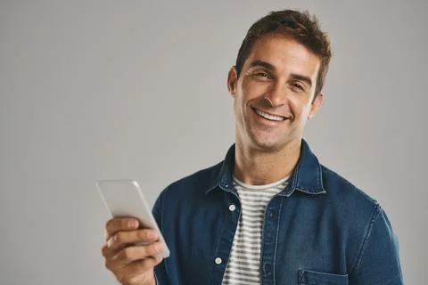 Got to stay in the loop. Studio portrait of a young man using a cellphone Stock Photos