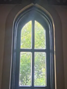Gothic arched window frame with green nature view Stock Photos