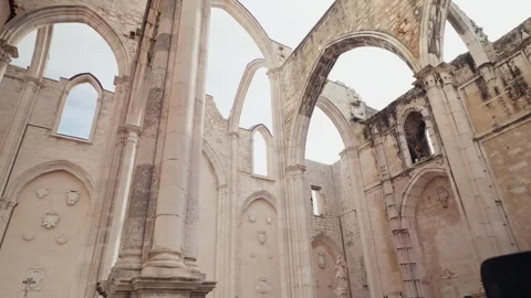 Gothic arches and stone columns of roofless Convento do Carmo ruins in Lisbon Stock Footage 332222448