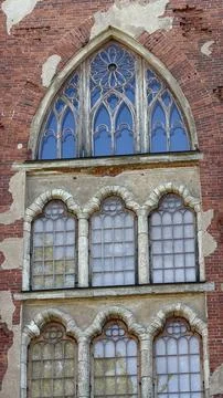 Gothic architectural facade featuring arched windows with blue glass Stock Photos