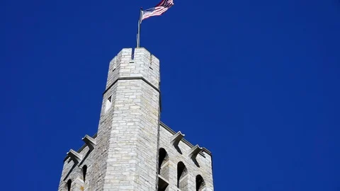 Gothic bell tower with American flag and parapet. 動画素材 128879541