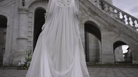 A Gothic Bride elegantly posing in a flowing wedding dress at a historic castle Vidéo 276827442