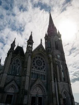Gothic cathedral facade against dramatic cloudy sky Stock Photos