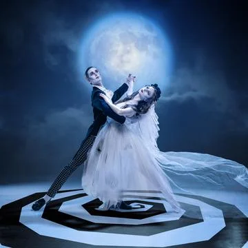 Gothic couple dancing in moonlight with dramatic pose on spiral stage Stock Photos