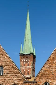 Gothic spire framed by brick gables. Stock Photos