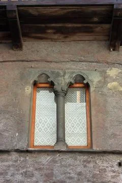 Gothic-style window with stone column in a mountain village Stock Photos