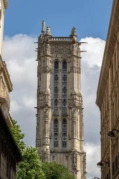 Gothic tower between buildings under blue sky in Paris, France Gothic towe... Fotos de archivo