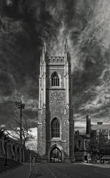 Gothic tower in front of bright blue sky with white cirrus clouds Stock Photos