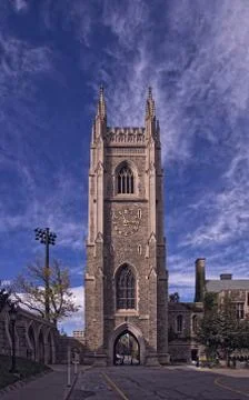 Gothic tower in front of bright blue sky with white cirrus clouds Stock Photos