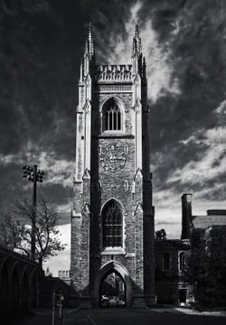 Gothic tower in front of bright blue sky with white cirrus clouds Stock Photos