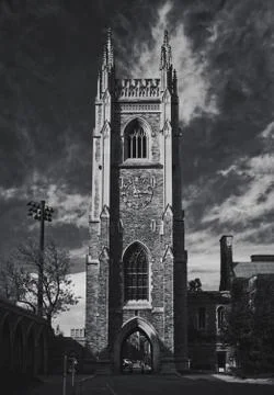 Gothic tower in front of bright blue sky with white cirrus clouds Stock Photos