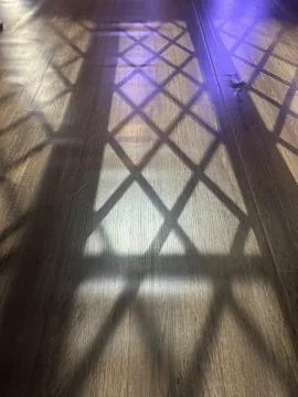 Gothic Window Shadow Pattern on Wooden Floor With Dramatic Light Rays Stock-Fotos