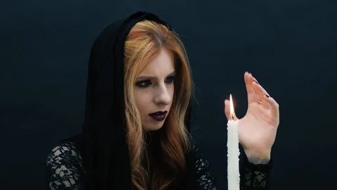 Gothic witch with candle on dark background Stock Footage 117536122
