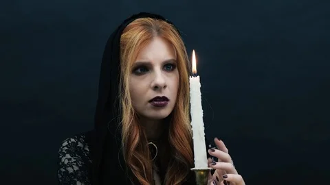 Gothic witch with candle on dark background Stock Footage 117540024